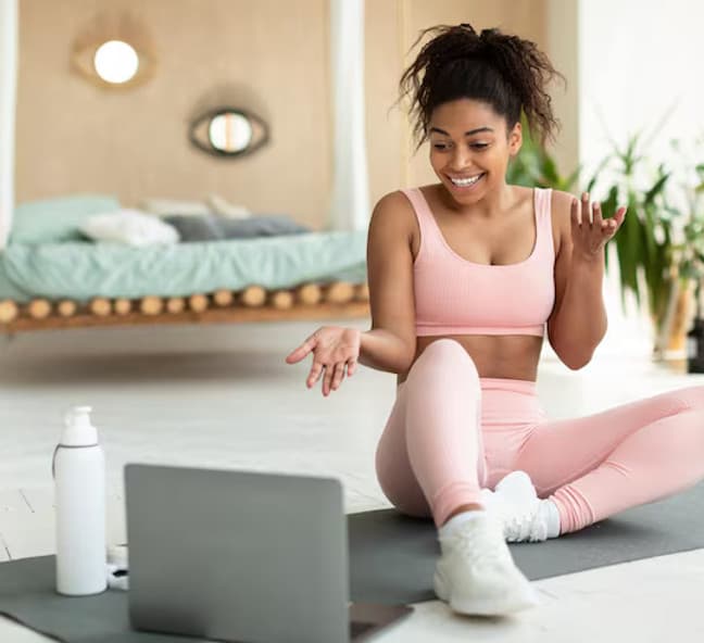 Client doing an exercise session at home guided by an online coach Client doing an exercise session at home guided by an online coach